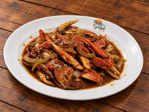 Crab with a light coating of sauce on a Dwipantor-branded white plate at Charcoal Restaurant